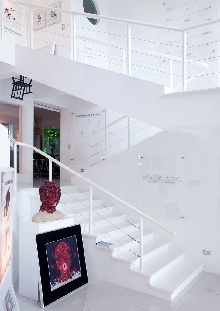 Main stairwell of the ArtLab, festooned with the surrealist works of Maxine and Cesare. The use of "museum white" tones creates a feeling of airiness, unity and cleanliness that defines the Modernist sensibility of the family. The steel tube and cable balustrades accent the industrial aesthetic of this Modernism.