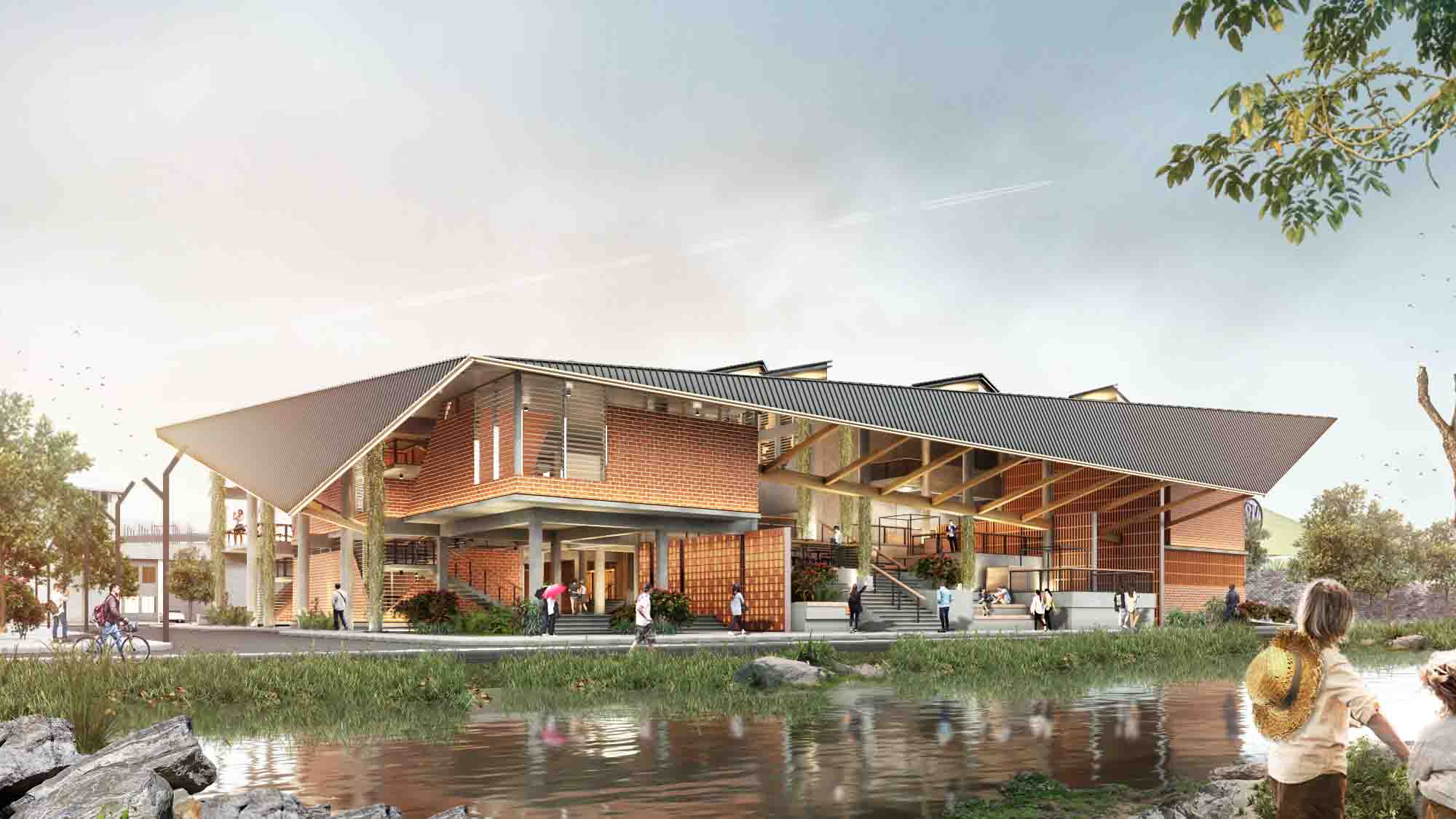 Large community center with slanted roofs overlooking a small lake.