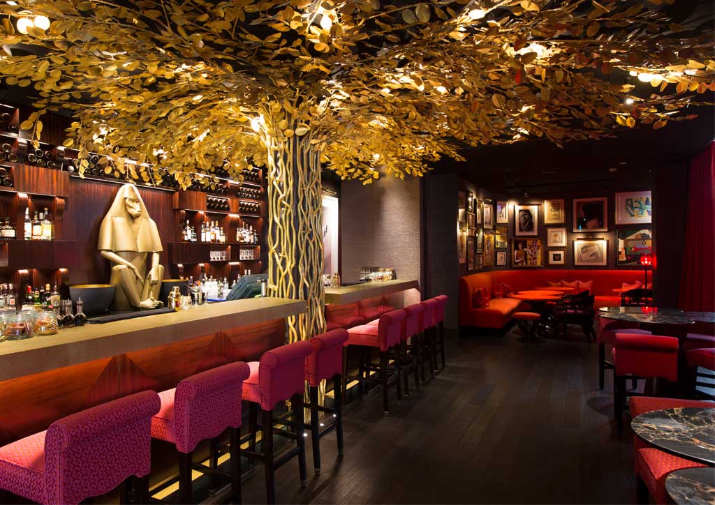 An artificial golden tree hangs above the plush bar area of Hotel Vagabond.
