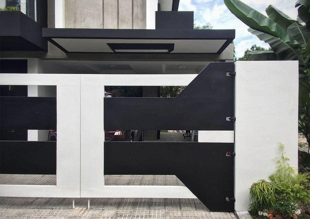 A modern home's front gate made of black and white steel.