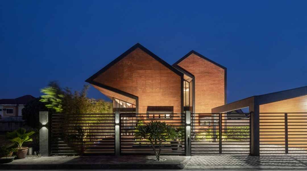 A modern two storey house design made of brick an black metal accents with a cantilevered orientation.