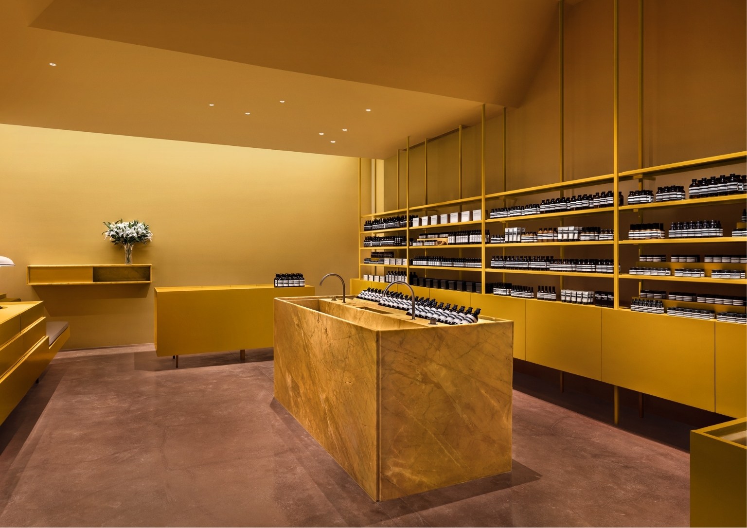 Aesop store's interior with a center marble island to showcase products.