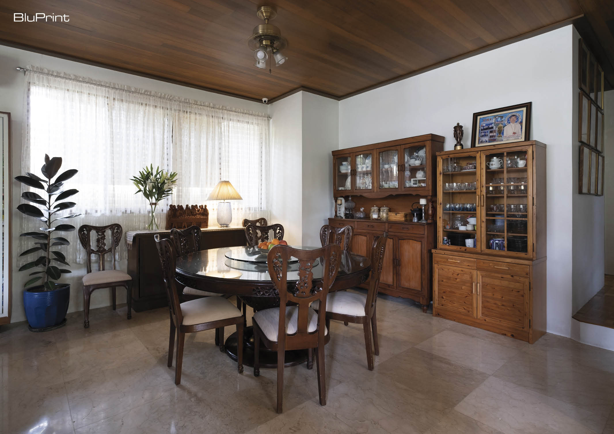 A dining room featuring a round traditional dining table and four chairs in the center, and wooden cabinetry on the far wall