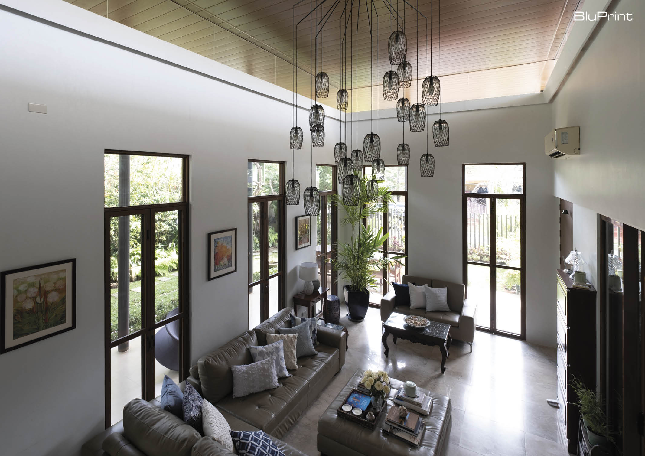 View of the living room with modern chandelier and double height ceilings