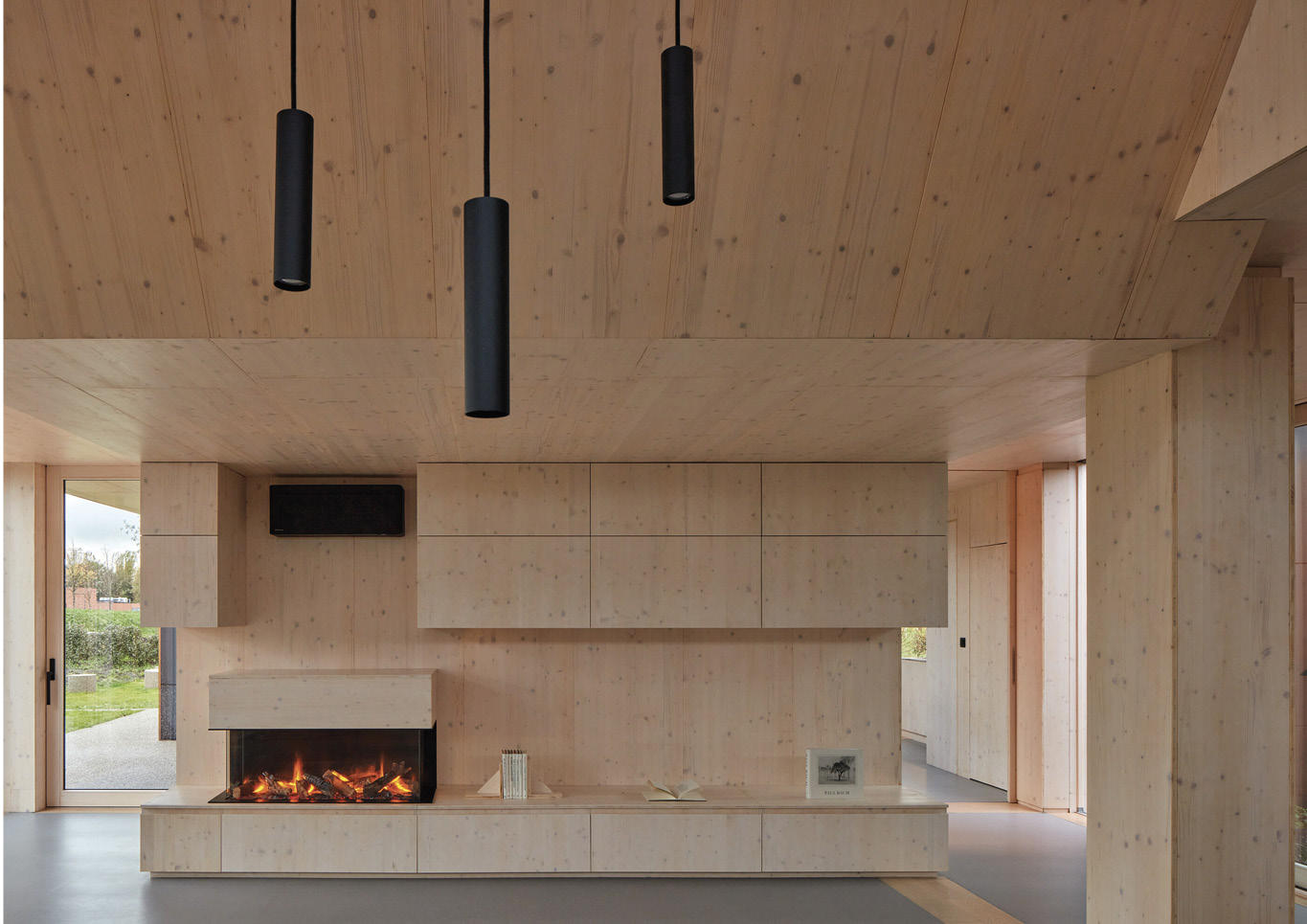 A fireplace with light colored wooden cabinetry inside Warm Nest, a Maggie care facility.
