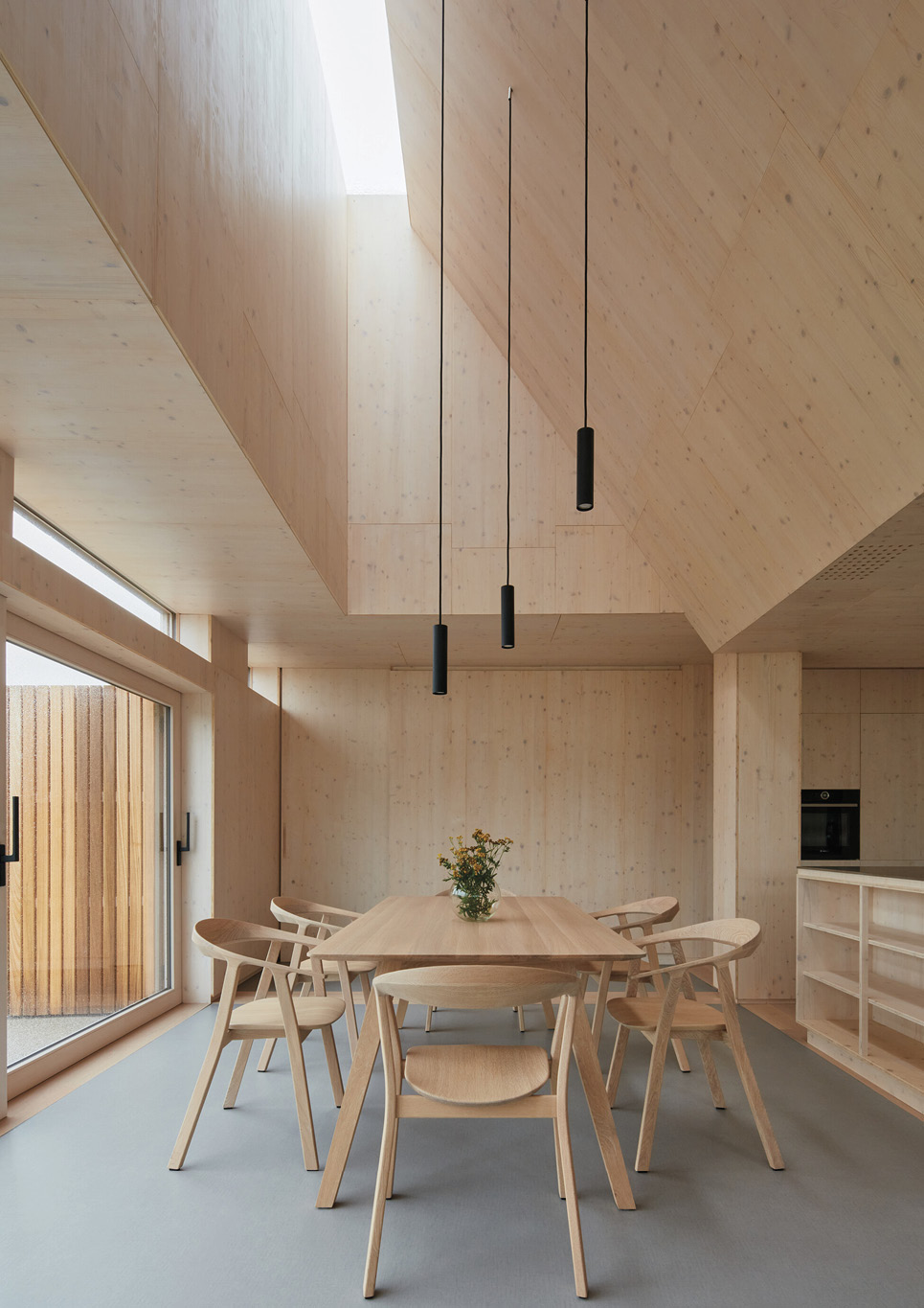 A dining area surrounded by wooden walls and ceilings inside Warm Nest, a Maggie care facility.
