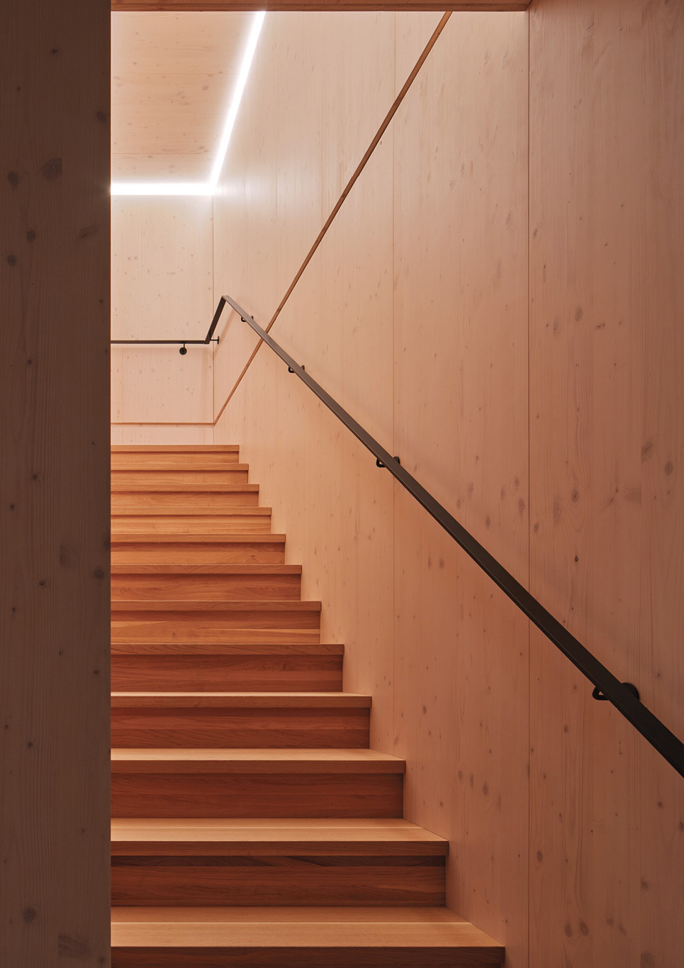 A wooden staircase inside Warm Nest, a Maggie care facility.