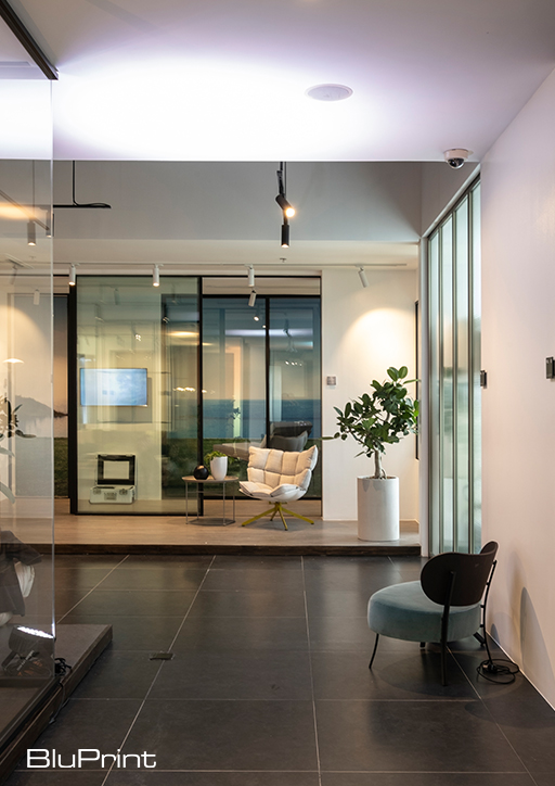view of a showroom featuring wood flooring, modern furniture pieces, and glass dividers