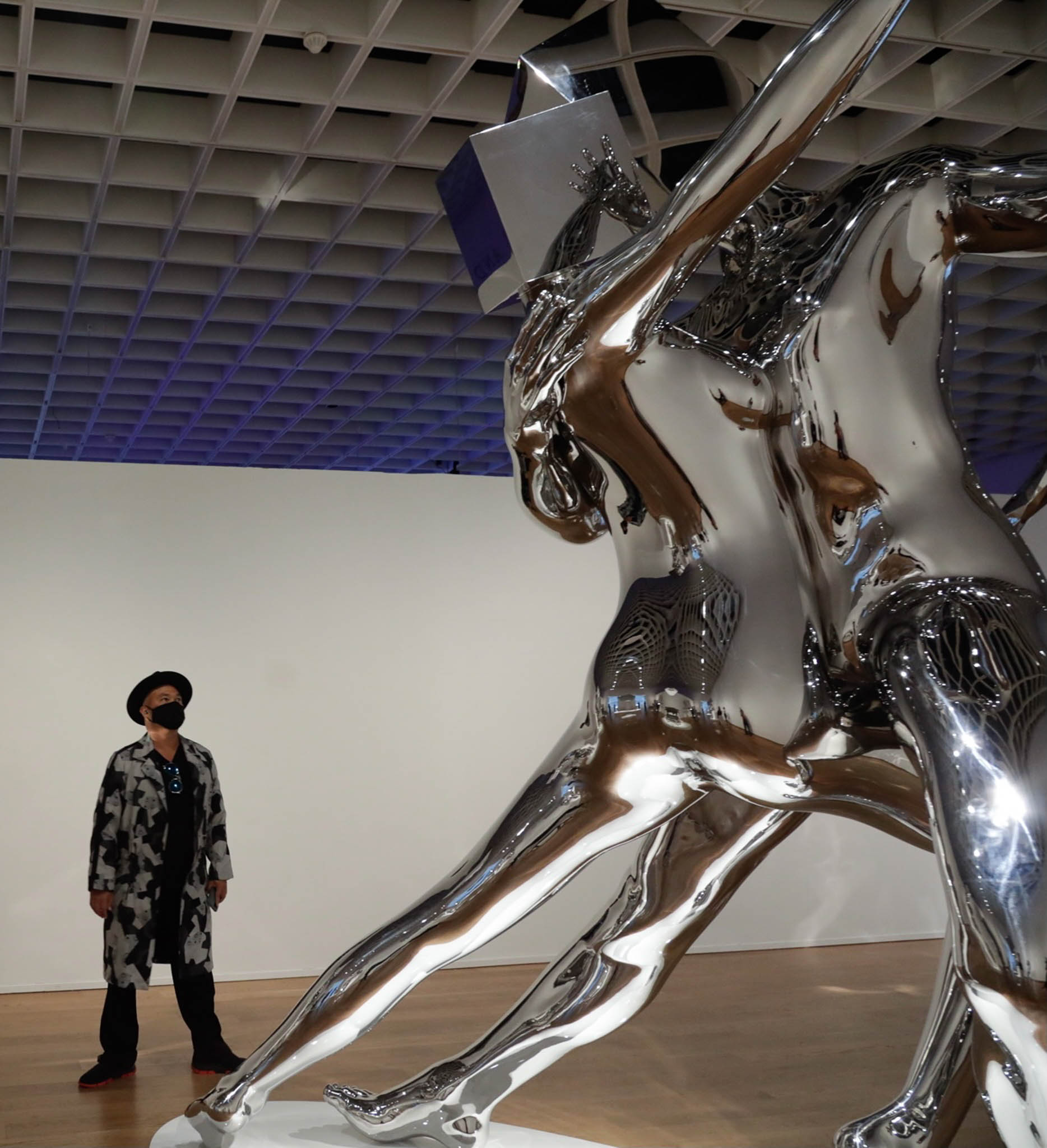 The artist standing next to one of his iconic metallic sculptures, "Passion"
