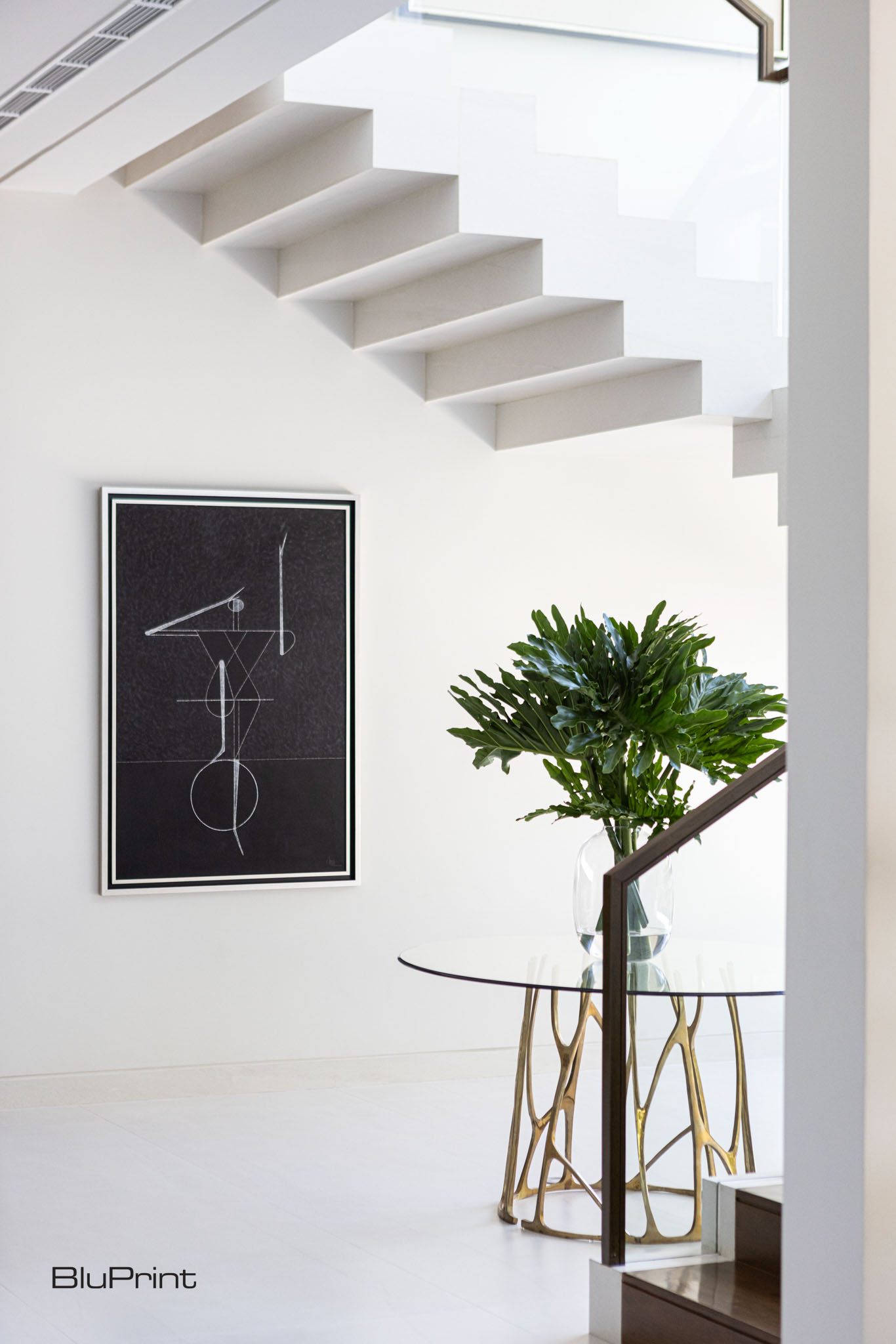 A stairway with natural light and minimalist furniture and art work