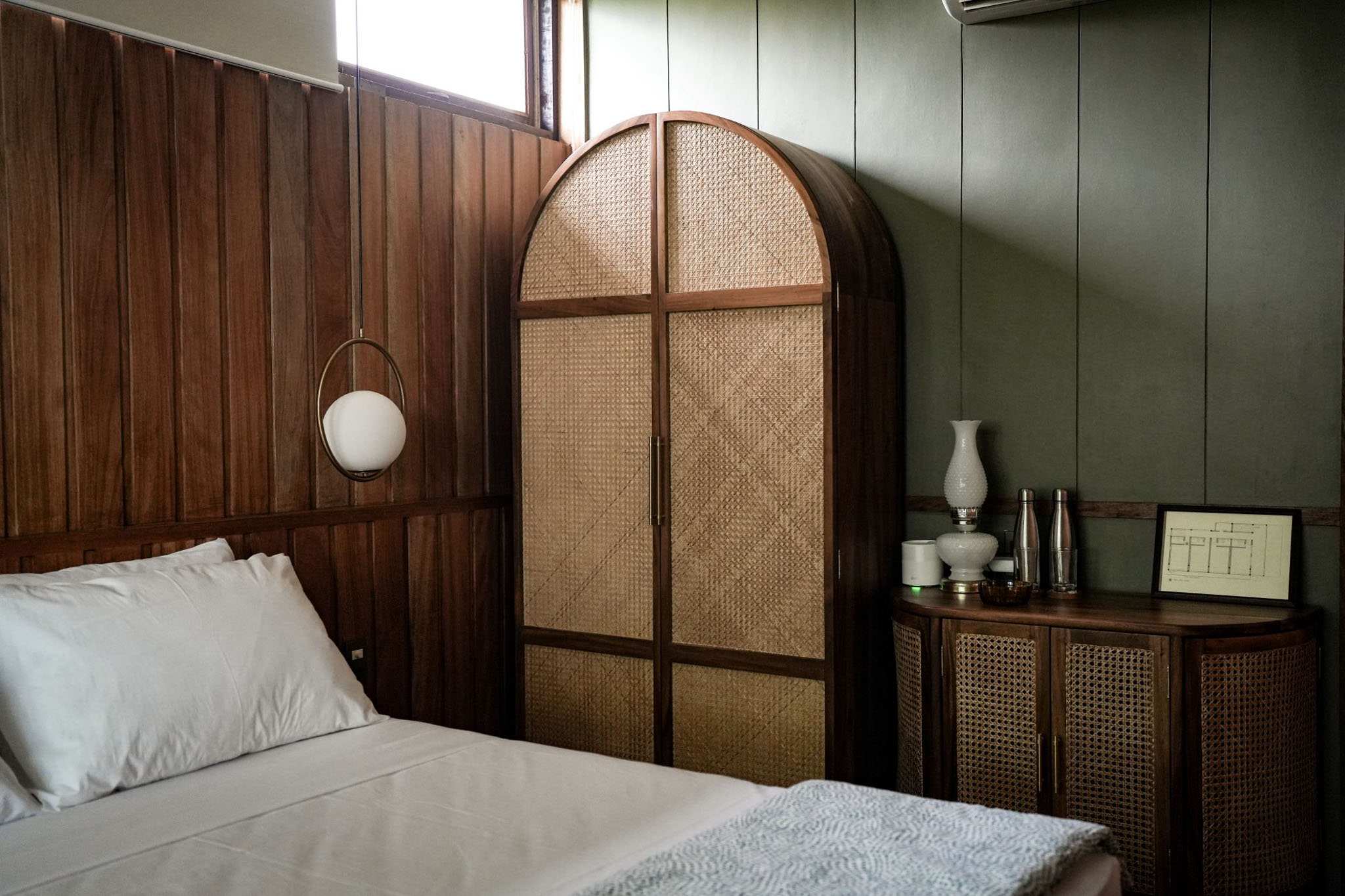 A bedroom in the Lark located in San Juan, La Union, with a traditional closet with woven doors and reclaimed wood wall panels.