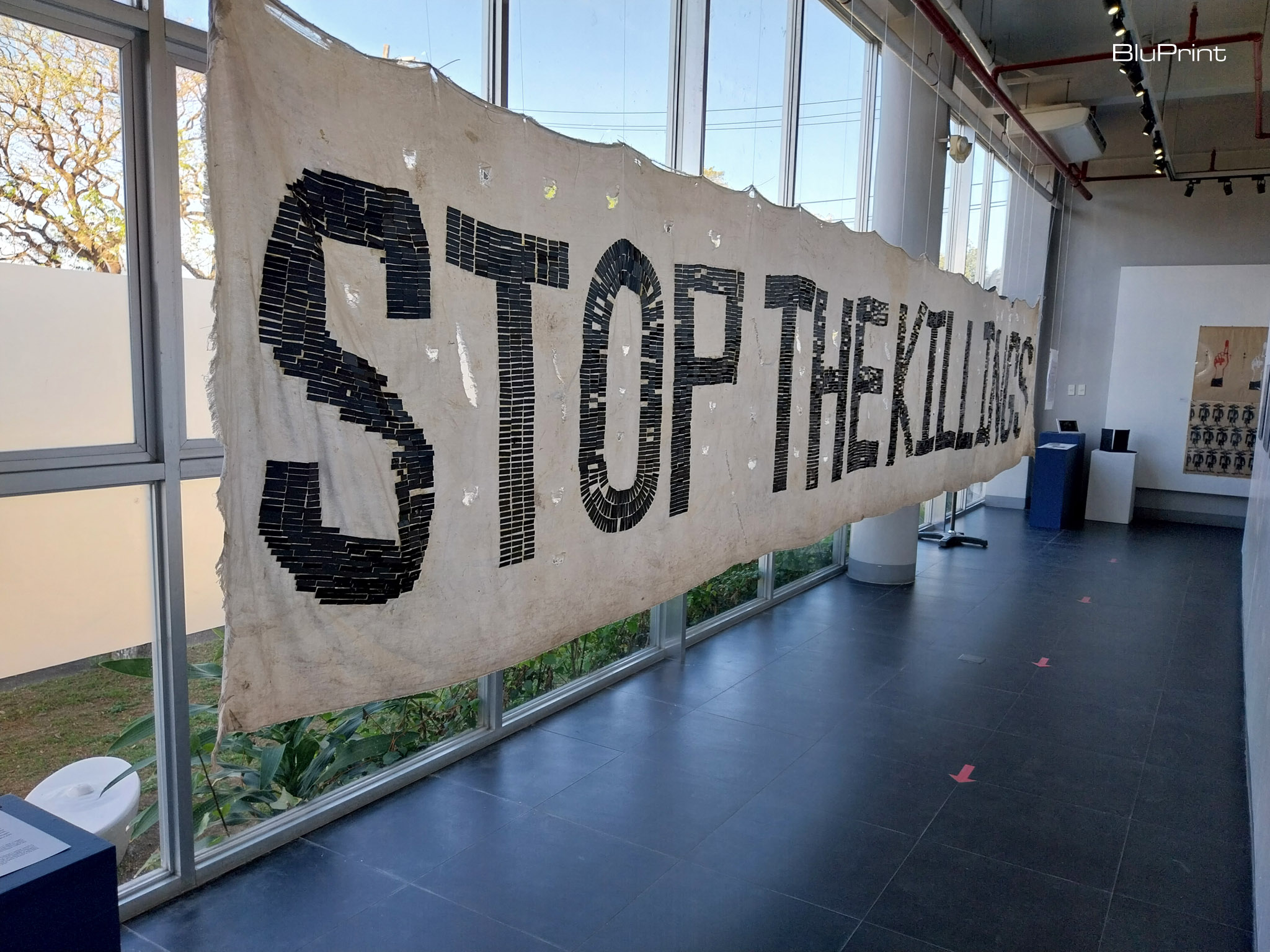The "Stop the Killings" banner by RESBAK shown at the "Warm Bodies" exhibit. Photo by Elle Yap.