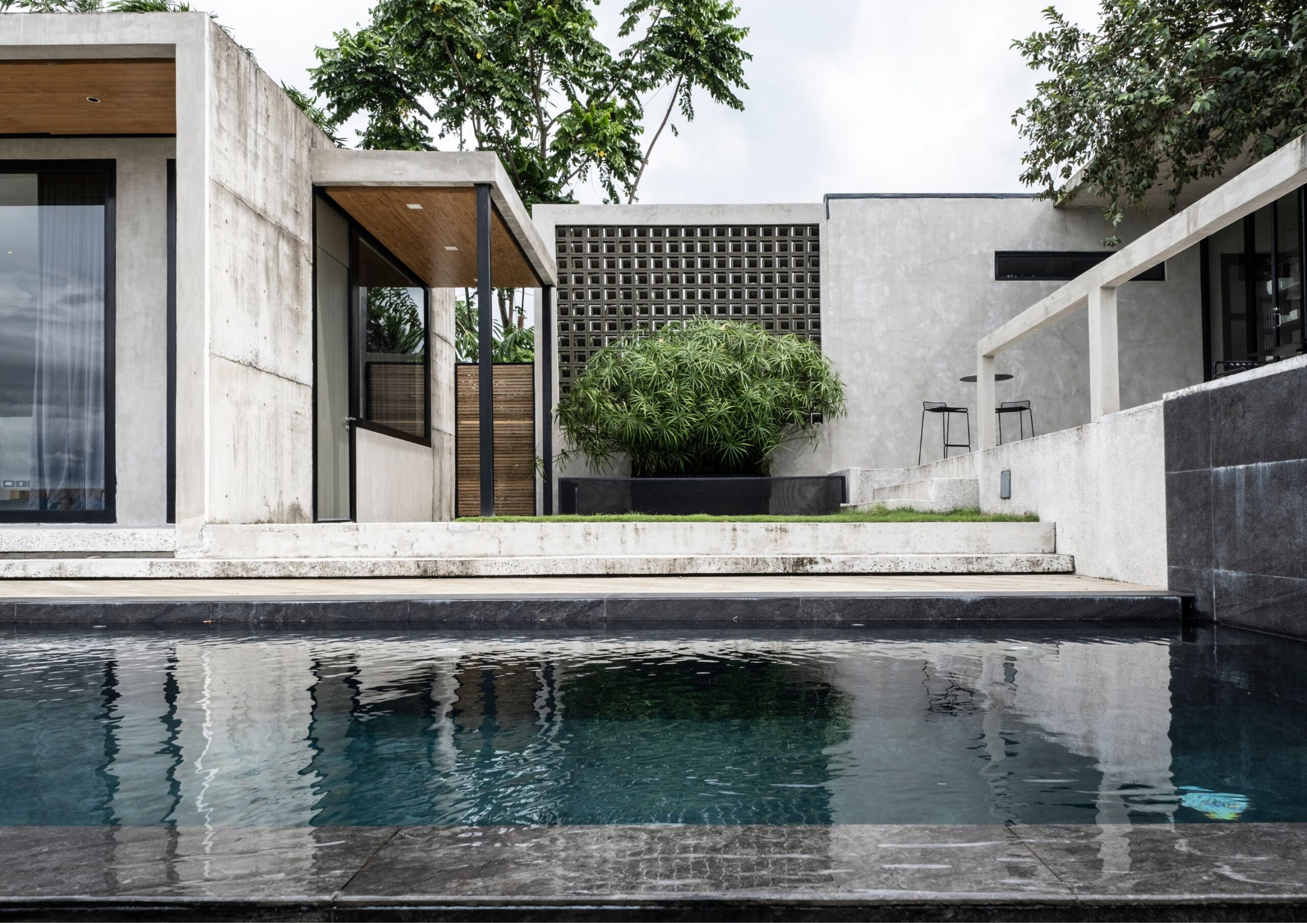 An infinity pool at Parallel, with an open courtyard made of concrete in Tanauan, Batangas.