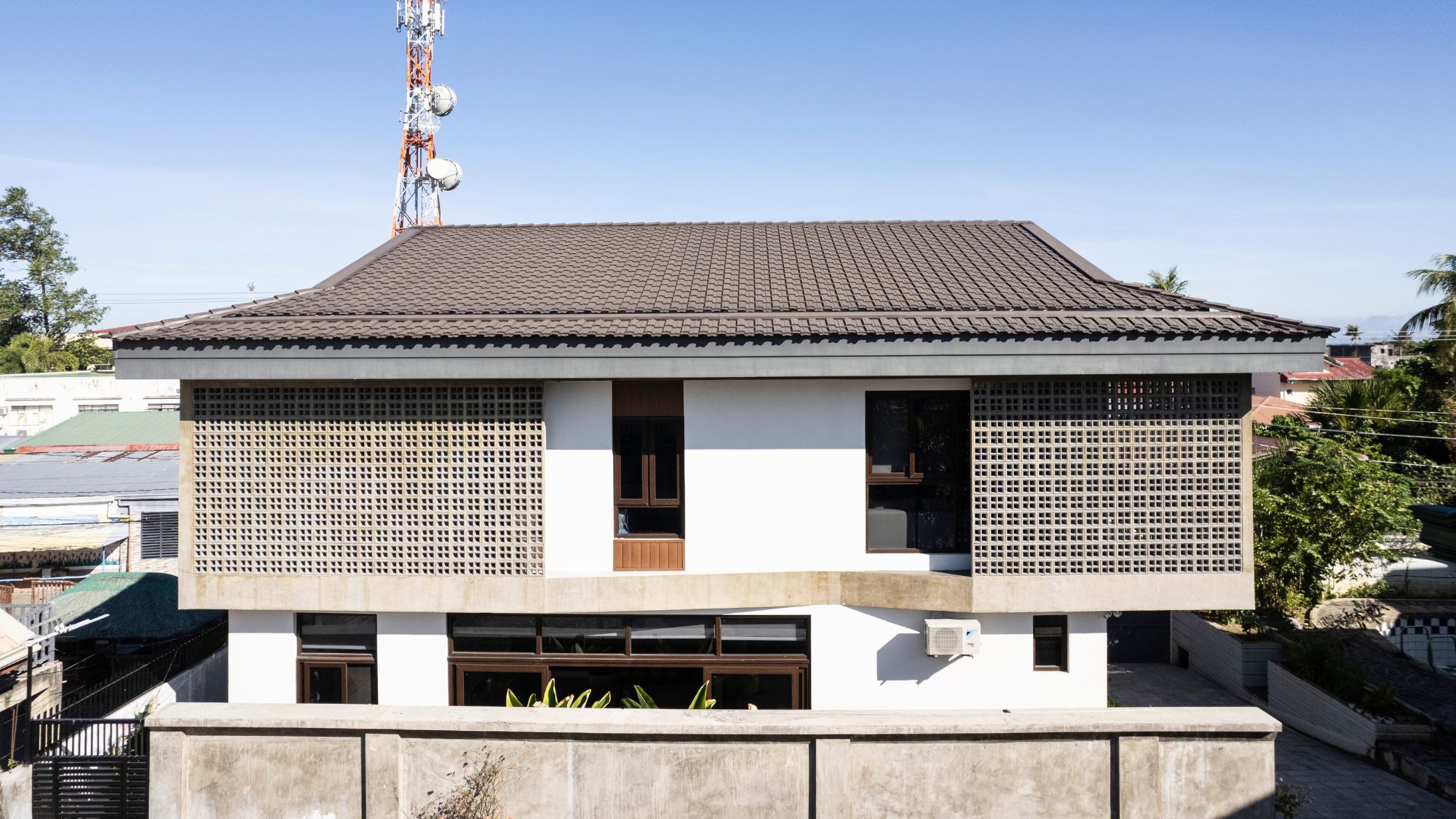 facade of Tabing Bahay, a modern intepretation of the bahay na bato, with a dutch roof and concrete screens.