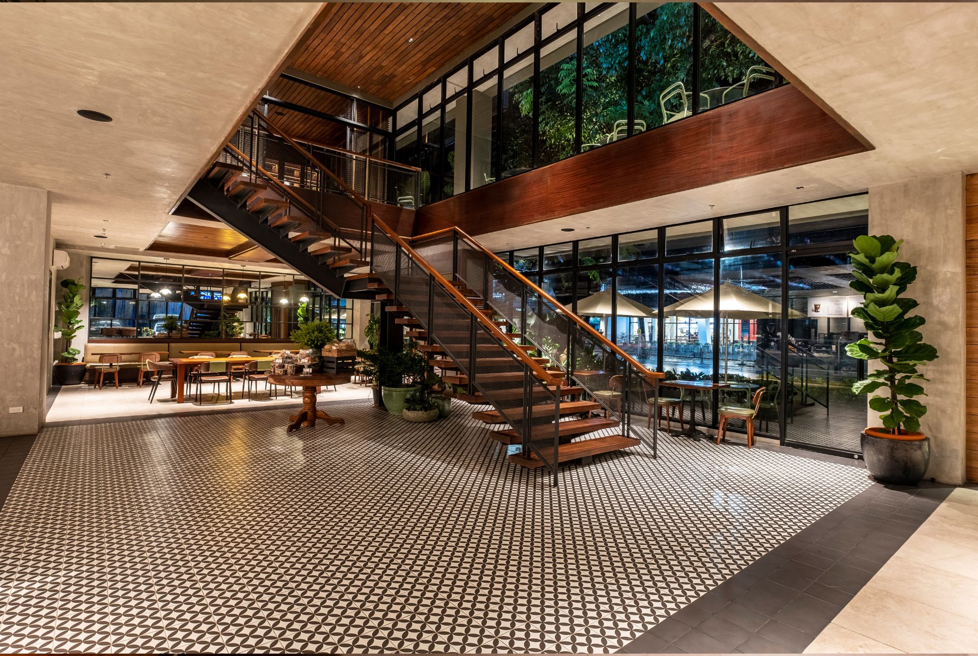 The central staircase in a wide open space at Cafe Bobs designed by Larawan Ink, with wooden treads and metal balustrade.