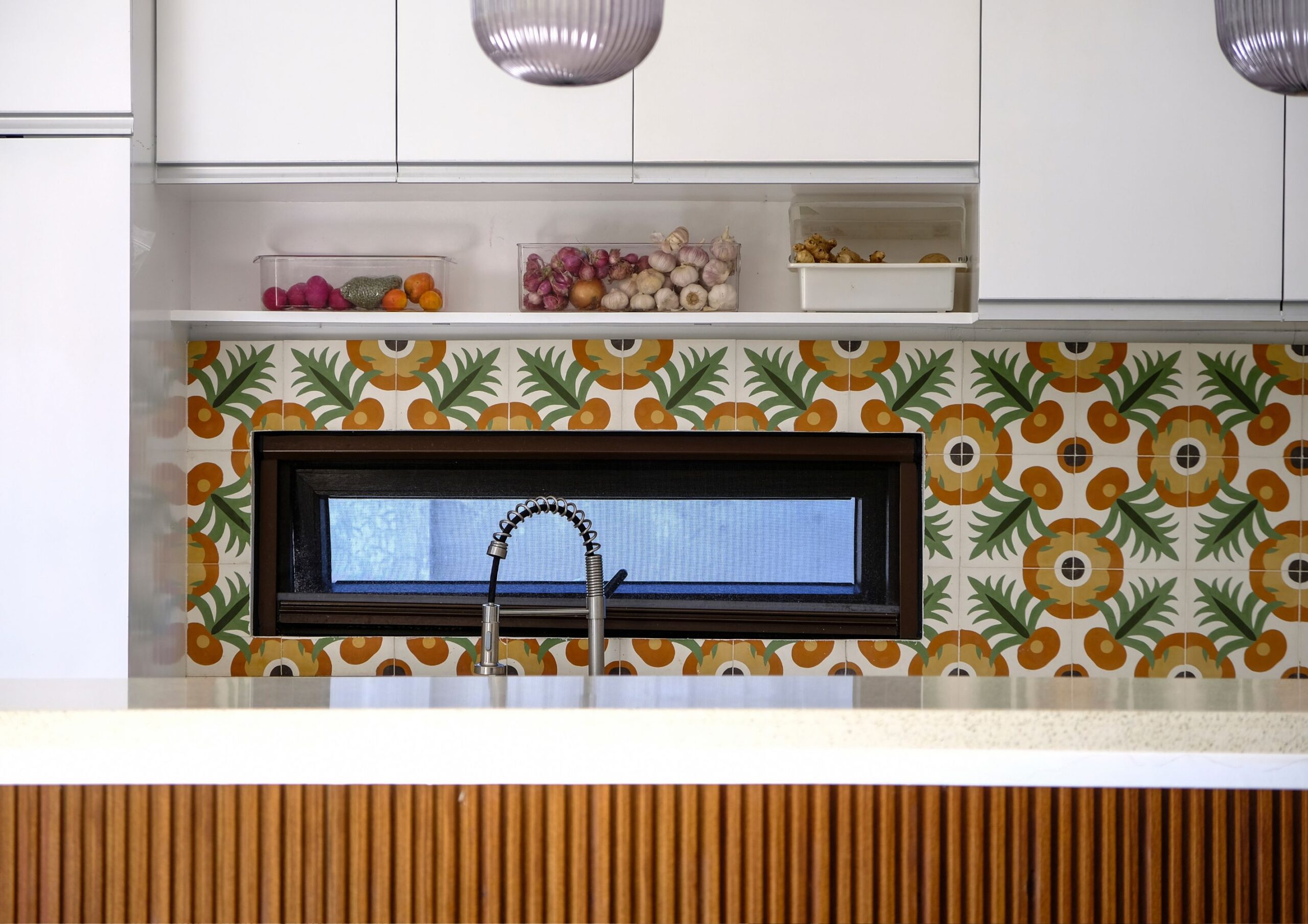 a modern kitchen with colorful patterned tiles, a small window, and kitchen island.