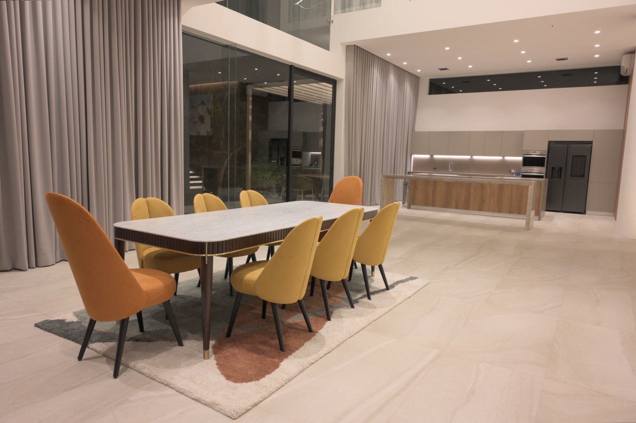 Modern dining room with kitchen in view. 