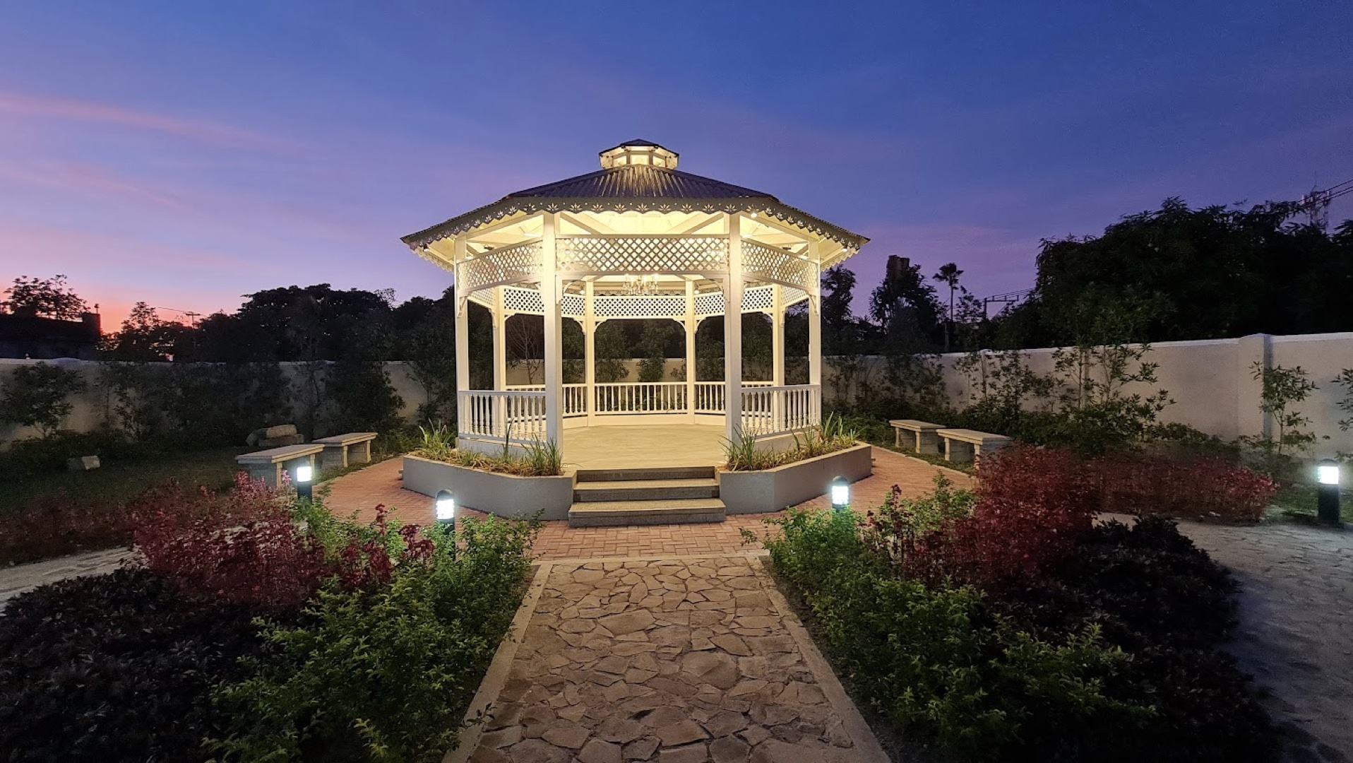 A gazebo in the middle of large garden.