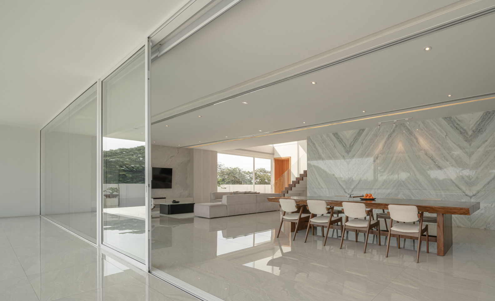 The dining and living rooms of a minimalist home in Thailand. Photos by DOF Sky|Ground.