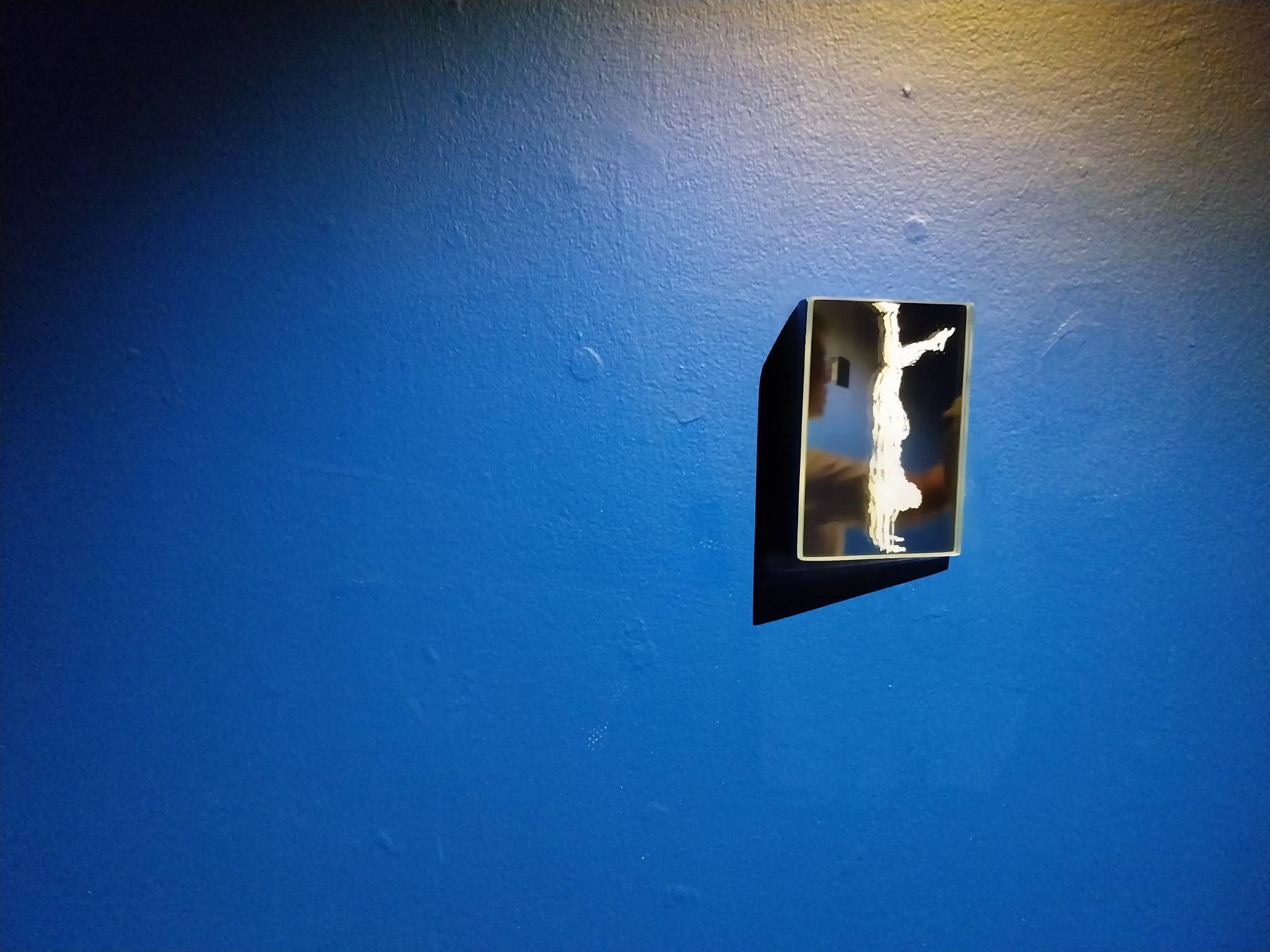 A mirror with a painting of someone mid-dance. Photo by Elle Yap.