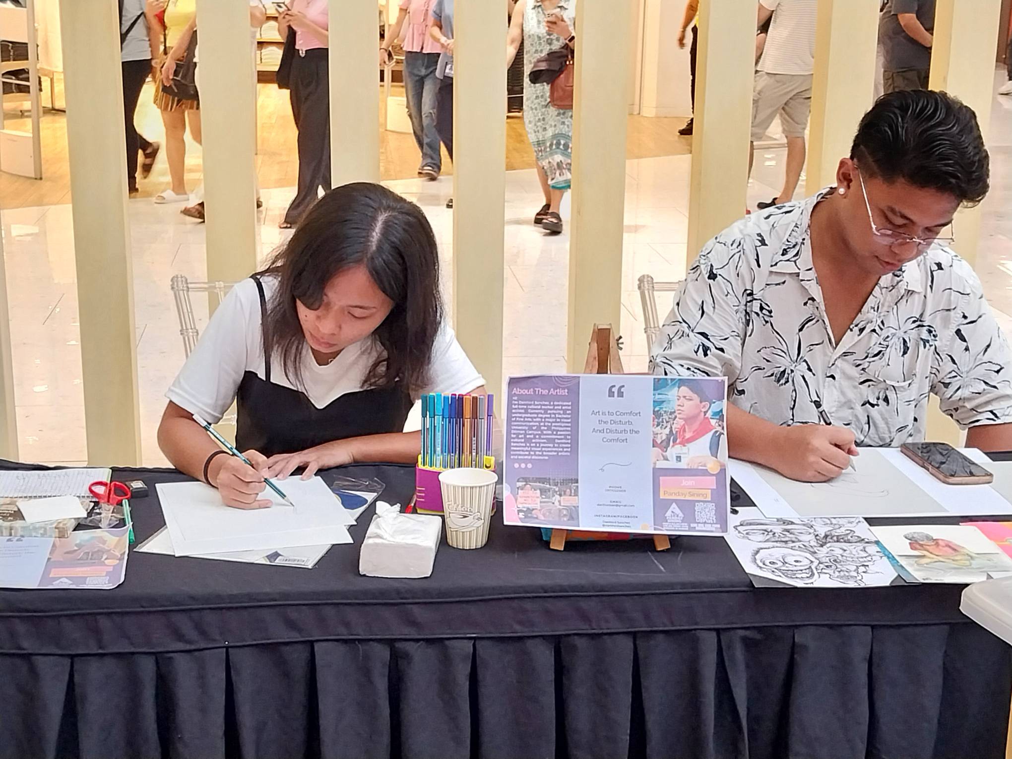 Two artists from Panday Sining in the midst of their work. Photo by Elle Yap.