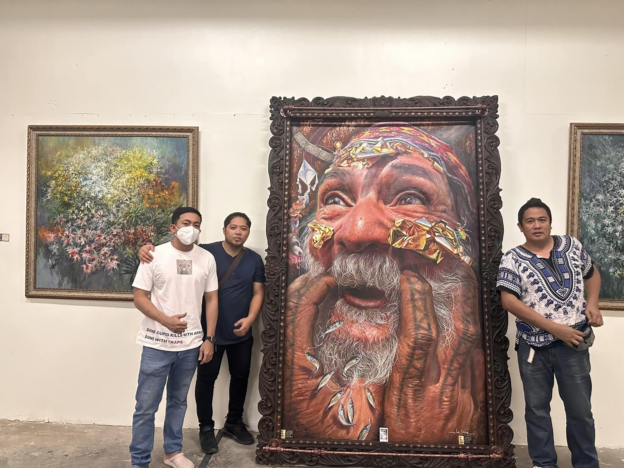 The artist (in the middle) posing with the artwork. Photo from Elvin Vitor.