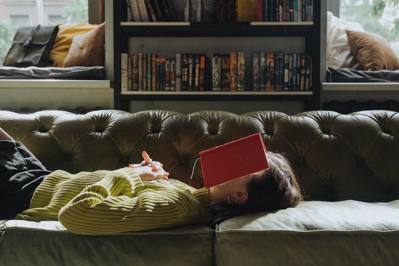 A person asleep with a book on their face. Photo by cottonbro studios. Source: Pexels.