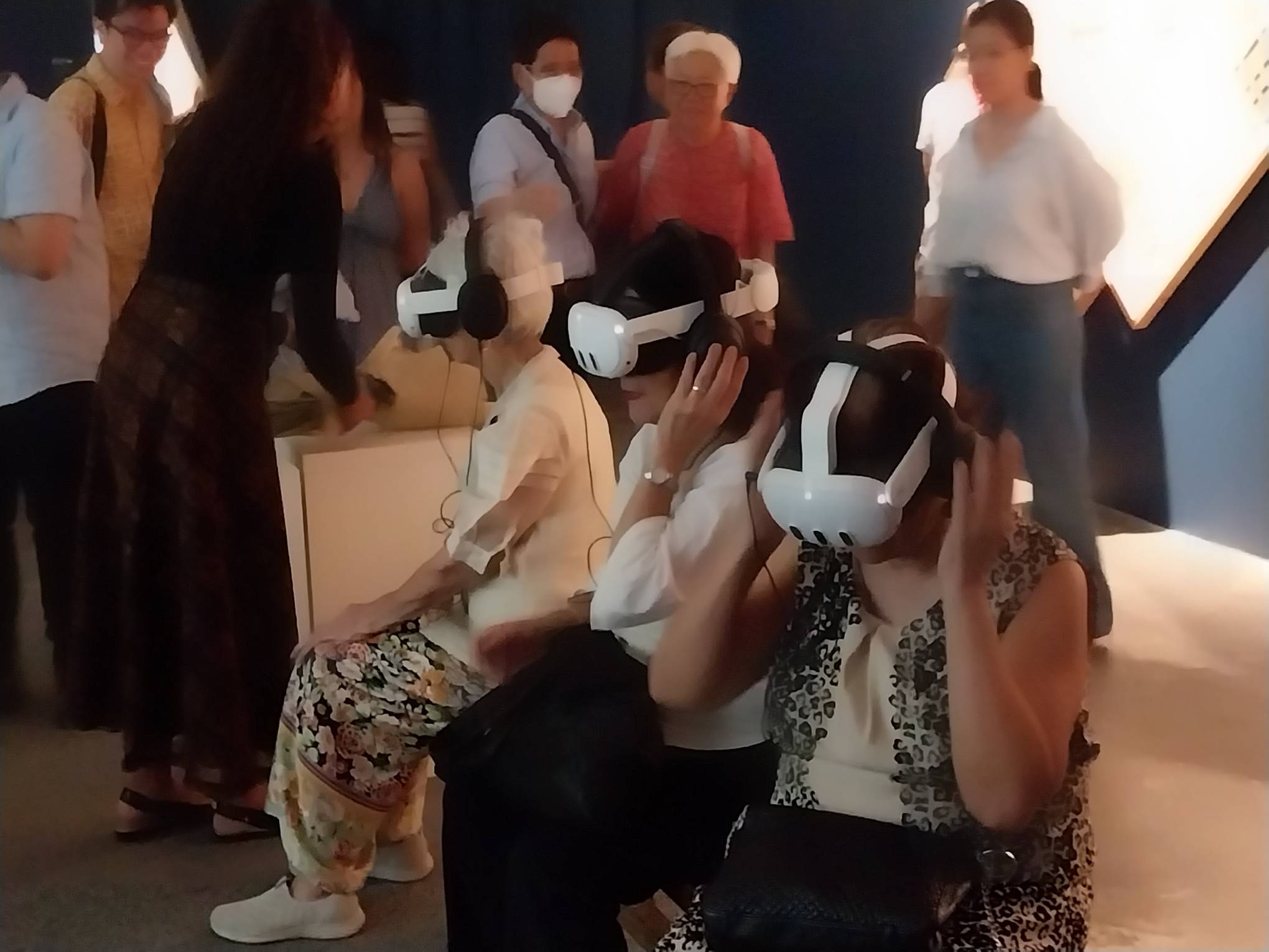Three spectators using the VR component of the exhibit. Photo by Elle Yap.