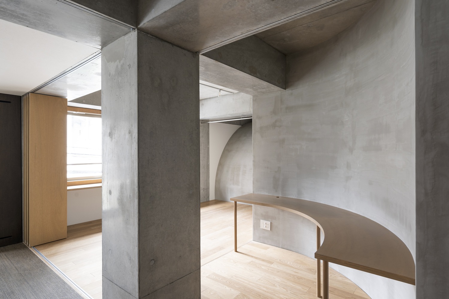 Wooden table next to a pillar. Photo by Masao Nishikawa.