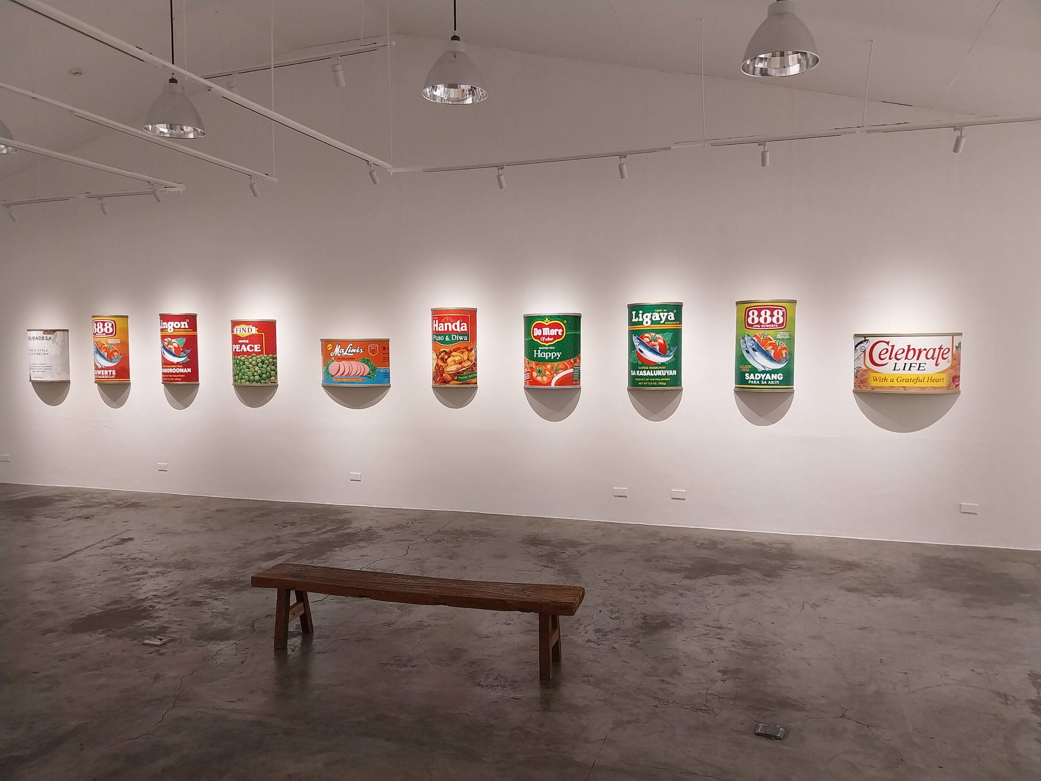 The brand parody sculptures mounted on the wall. Photo by Elle Yap.