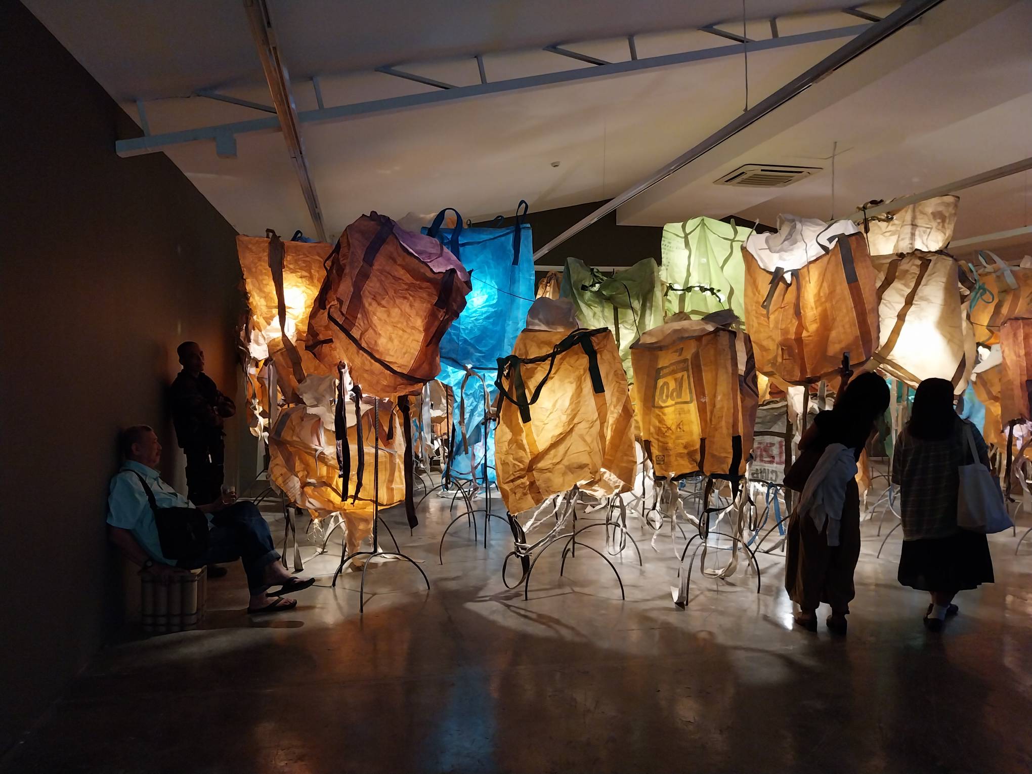 Visitors admiring Pete Jimenez's "Travel Light." Photo by Elle Yap.