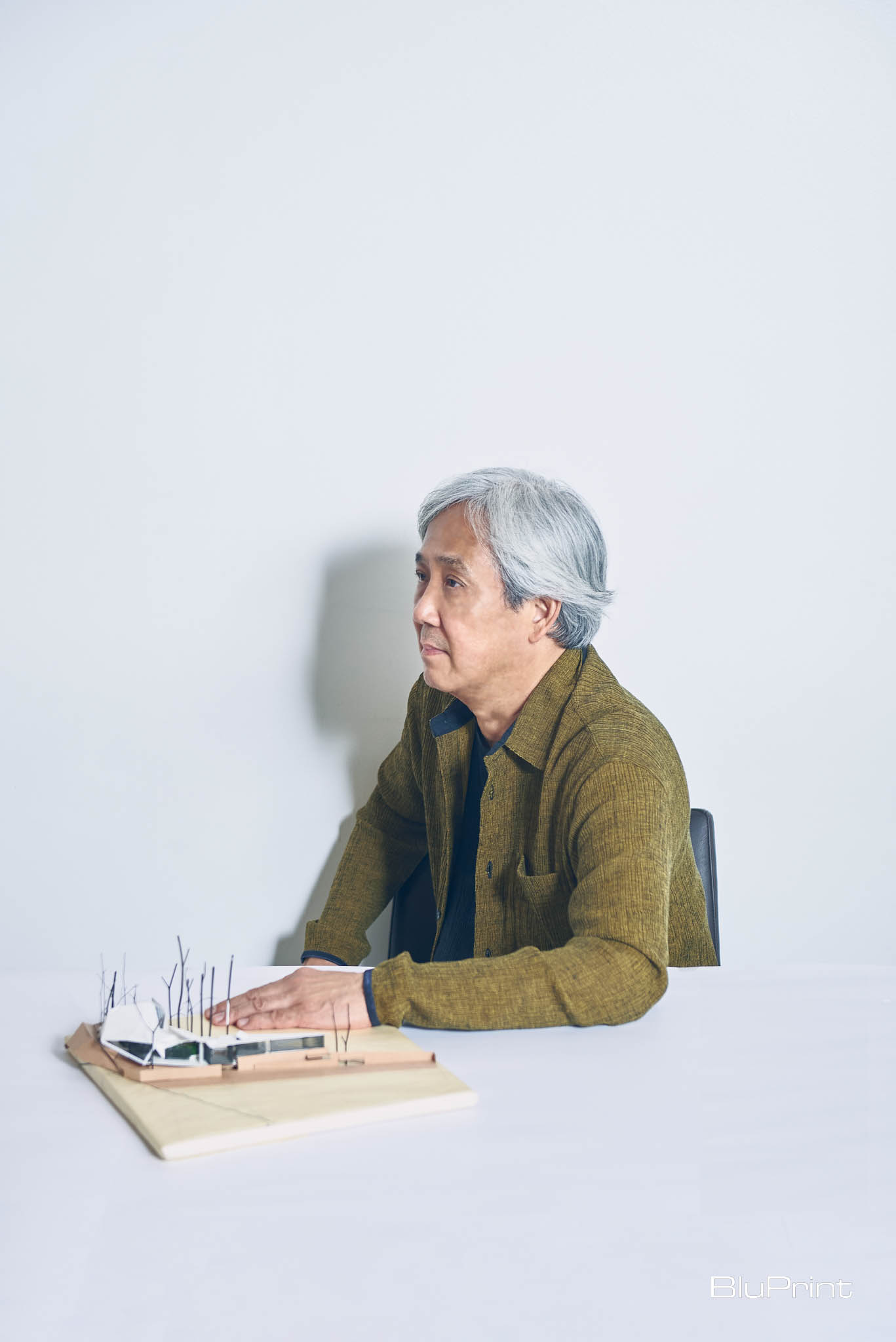 Profile shot of Joey Yupangco with a scale model of a farmhouse.