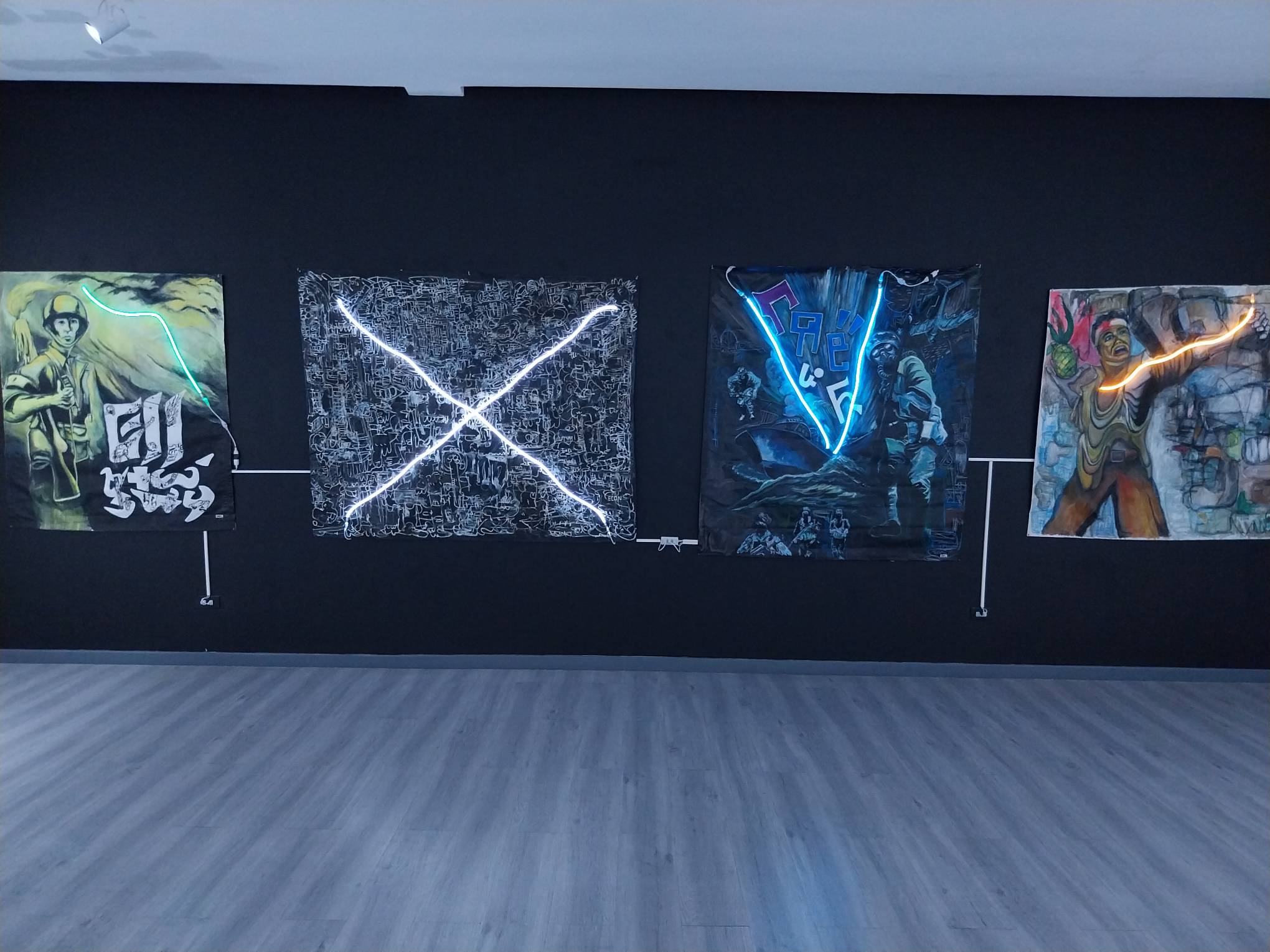 Four works by Ernest Concepcion affixed with LED lights to mimic neon billboards.