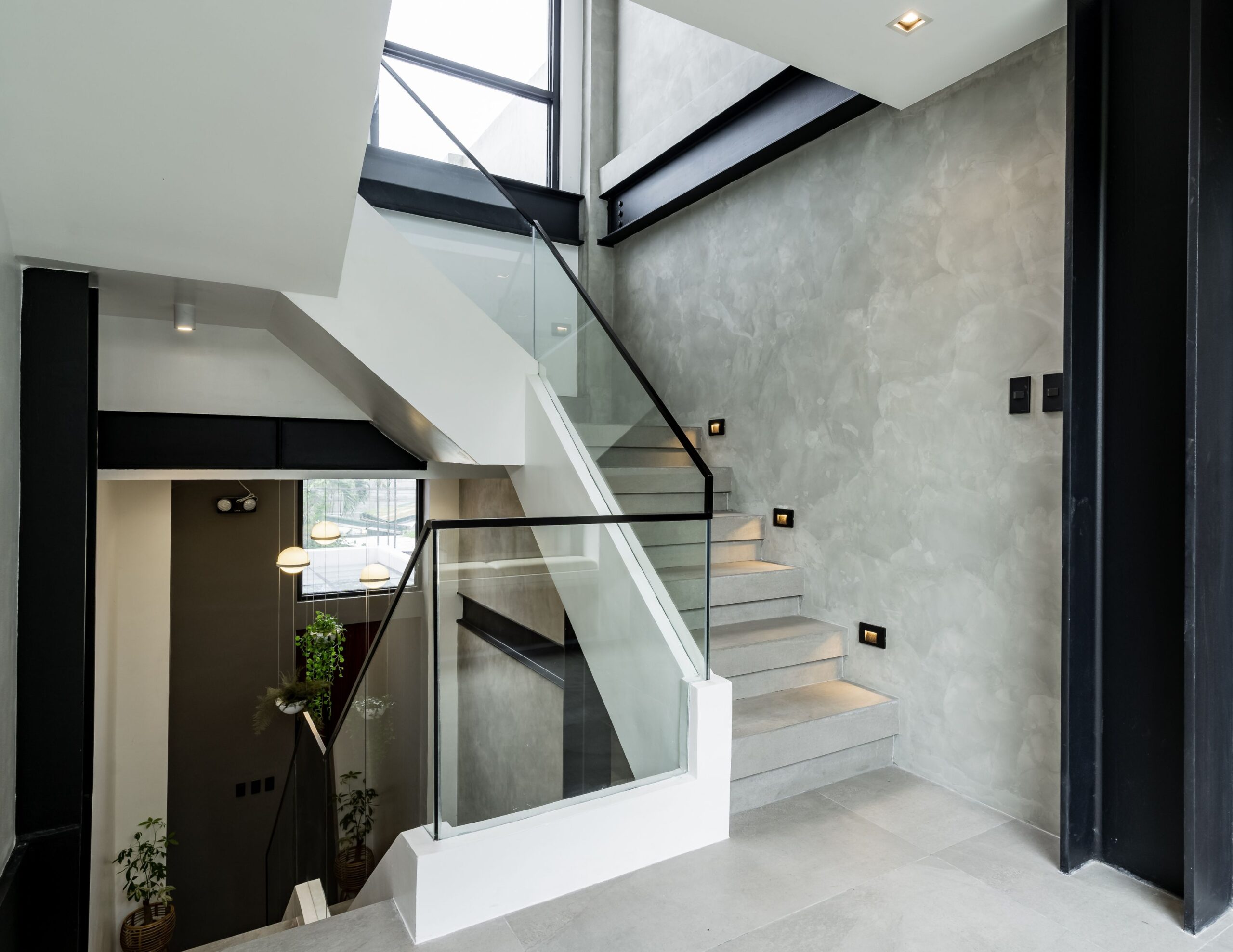 A well-lit stairwell connects all three levels of V House.