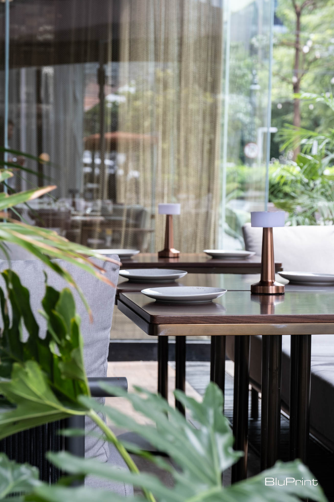 Tables with brass bases and wooden tops in Bolero.