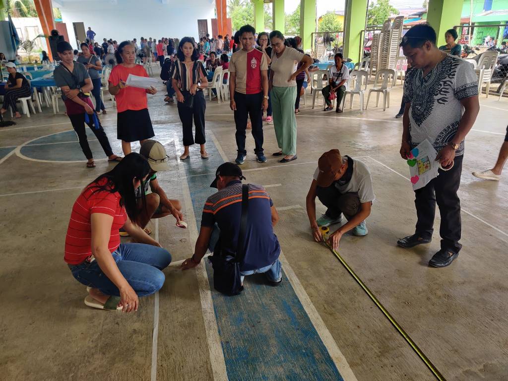 Some participants of the "Design Natin" workshop putting measurements on the ground.