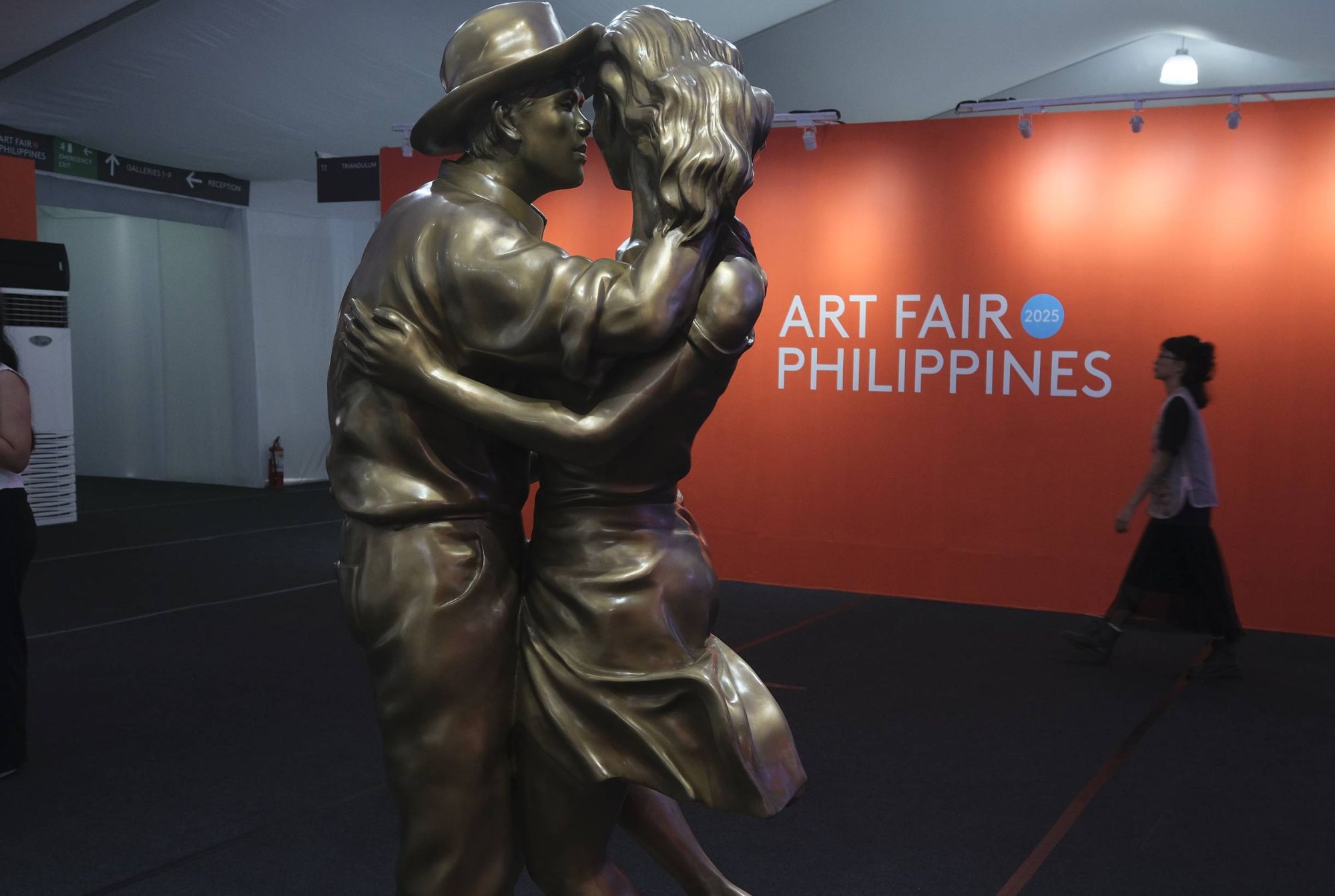 Art Fair Philippines sign with a sculpture of two people kissing.