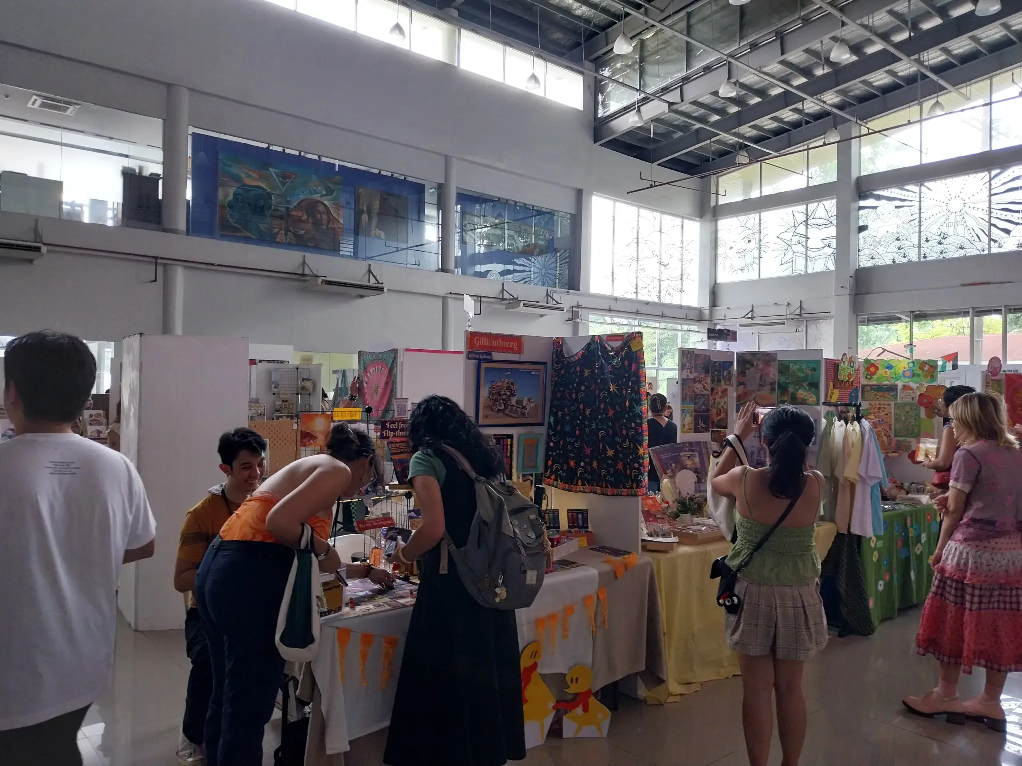 Artists and art enthusiasts buying and looking at artworks at the Manila Illustration Fair.