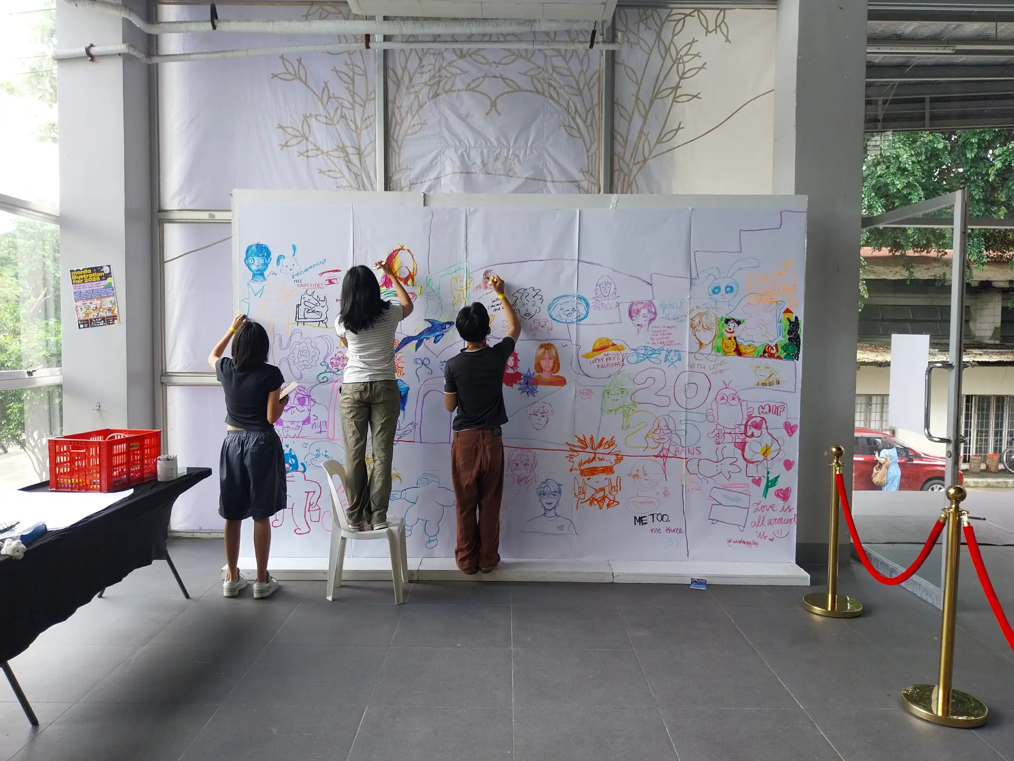 Some students adding to a big freedom wall for the Manila Illustration Fair.