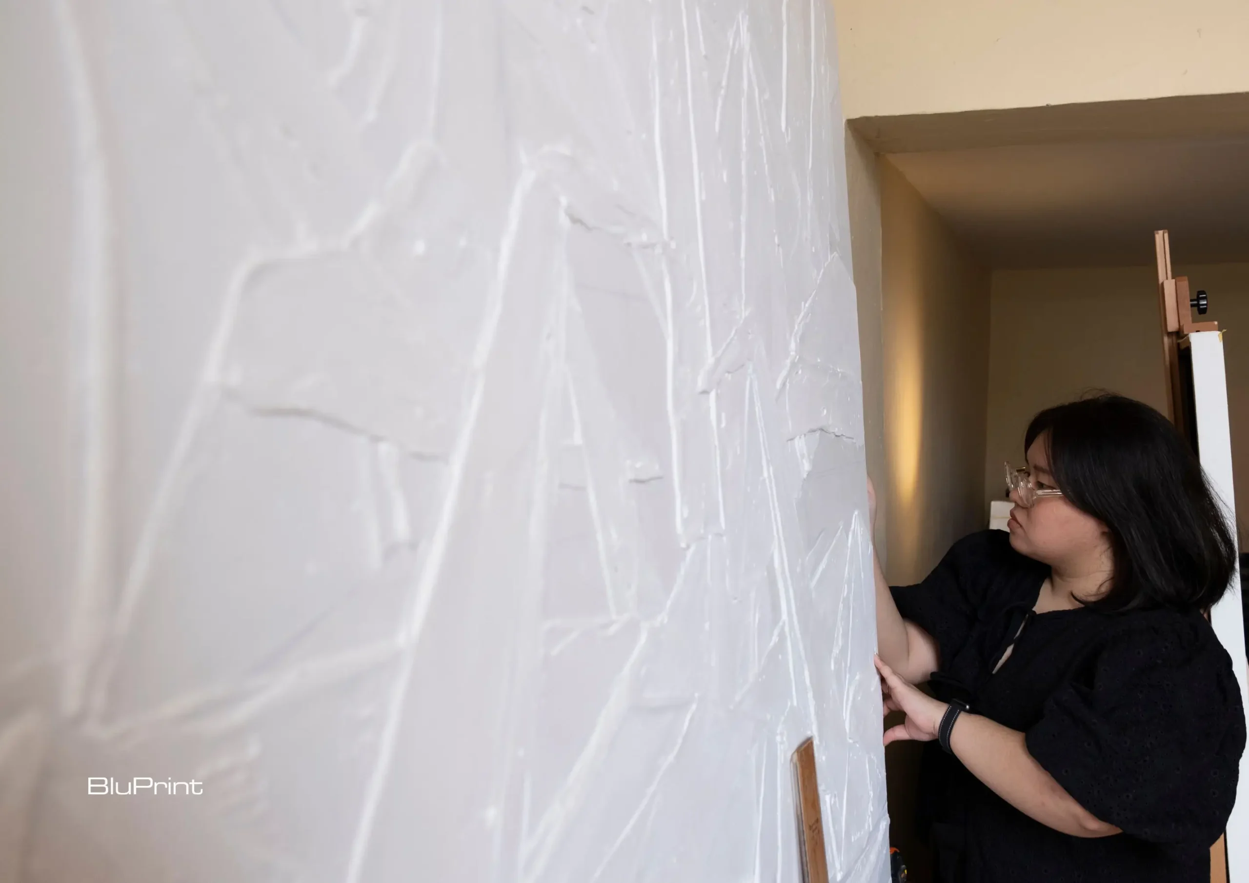 Thea Quiachon at work, with a blank canvas she is working on.